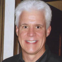 Photo of smiling white-haired man in black shirt